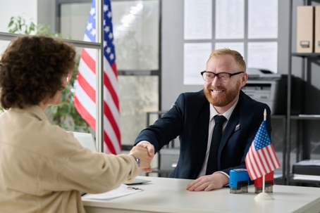 person shaking hands with immigration officer