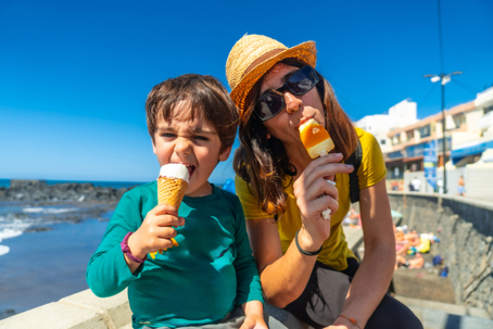 mother and son eating ice cream by the beach