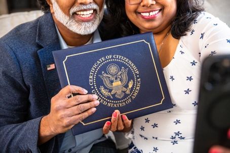 couple holding certificate of citizenship